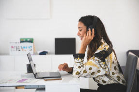 Professional woman at a laptop wearing headphones