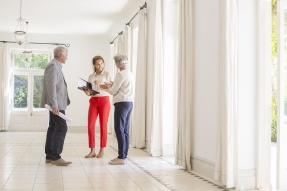 Real estate agent and couple in empty home