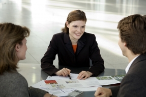 Real estate agent at table with clients