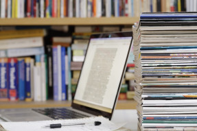 Stack of magazines and laptop computer