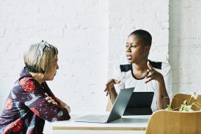 Two women sitting at a table and talking