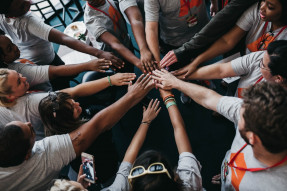 Volunteers with all arms in center of a circle