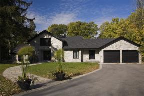 White stone house with a long driveway