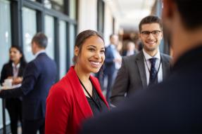 Woman in red blazer talking to colleagues