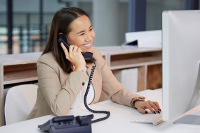 Woman on the phone at a computer in an office