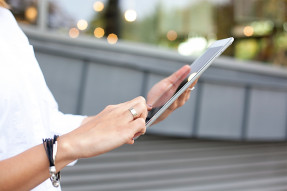 Woman wearing a white blouse and using a tablet