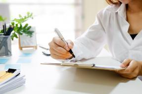 Woman with clipboard, pen, and post-its