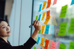 Women strategic planning with post-it notes on window