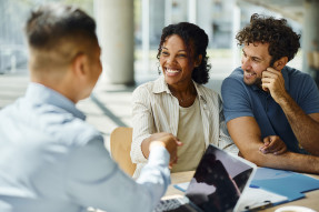 Young couple with agent in office