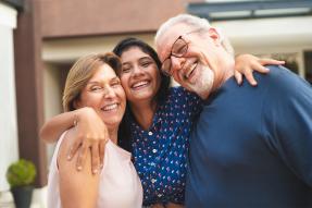 Young woman hugging an older couple