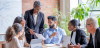 A group of diverse business professionals looking over a graph