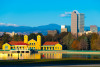 View of Denver skyline, the Rocky mountains, and a lake from a park