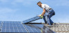 Workers installing solar panels on roof