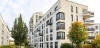 A picture of a large condo complex with trees and greenery in the courtyard.