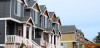 A row of houses grouped closely together leading down a neighborhood.