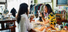 Smiling shopkeeper helping client at counter in boutique