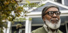 Older Black man in front of house