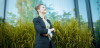 Woman standing in front of greenery