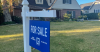 Home with realtor blue for sale sign