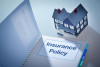 Handbook policy book diplayed in the foreground, with a residential home model in the background