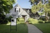 Light gray house with for sale sign on lawn