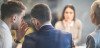 Male team member whispering to colleague during meeting