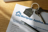 Mortgage application with key on house keychain and pen