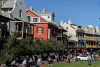 People gathering around a green field featuring home with balconies in the background in Rosemary Beach, FL