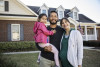 Portrait of family in front of suburban home