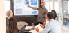 Man giving presentation to colleagues pointing to screen