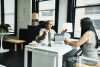 Two women having a conversation at a desk in an office