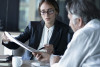 Young woman wearing a suit reviewing contract with a client